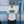 Man wearing a white t-shirt with a graphic design and text, standing in front of a blue van.